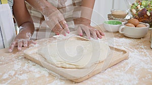 Closeup hands of African American family with daughter add egg to flour and thresh for cooking with father and mother.