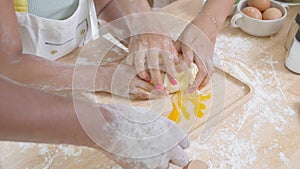 Closeup hands of African American family with daughter add egg to flour and thresh for cooking with father and mother together.