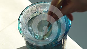 Closeup of hands artist kneads mixing art epoxy resin in plastic cup working in art studio workshop