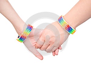 Closeup hands with a bracelet patterned as the rainbow flag. isolated on white
