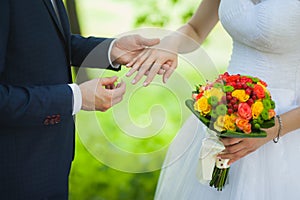 Closeup of hands of bridal unrecognizable couple with wedding rings. bride holds wedding bouquet of flowers.