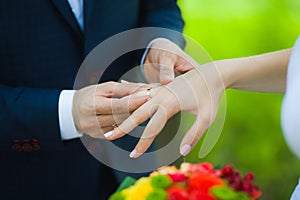 Closeup of hands of bridal unrecognizable couple with wedding rings. bride holds wedding bouquet of flowers.