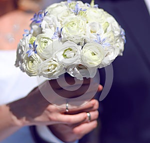 Closeup hands of bride and groom holding wedding white bouquet
