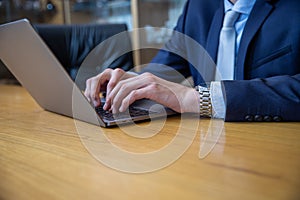 Closeup of the hands of a businessman typing on his laptop keyboard with copy space underneath