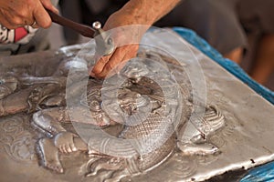 Closeup of hands carving silver. Process of silver carving, Chiang Mai, Thailand