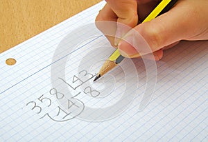 Closeup on the hands of a child doing maths