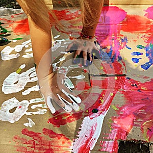 Closeup of hands of a child painting - colorful hands on a school activity art lab