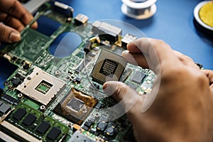 Closeup of hands with computer mainboard microprocessor electronics parts