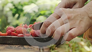 Closeup hands cutting red ripe strawberry. Summer food.