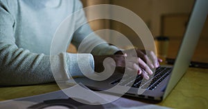 Closeup on hands of an entrepreneur typing and responding to email on a laptop during late shift in the office. Zoomed