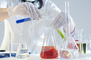 Closeup of Hands of Female Laboratory Staff Working With Liquids Specimens in Flasks