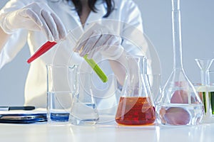 Closeup of Hands of Female Laboratory Staff Working With Liquids Specimens in Flasks in Laboratory