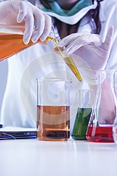 Closeup of hands of Female Laboratory Worker Dealing With Flasks