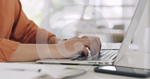 Closeup hands and fingers of a business woman working on a laptop in her office. Female entrepreneur typing on her