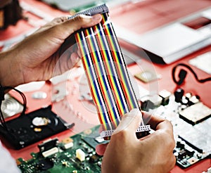 Closeup of hands holding computer breadboard flat wires cables