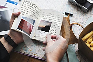 Closeup of hands holding journey diary notebook over map background