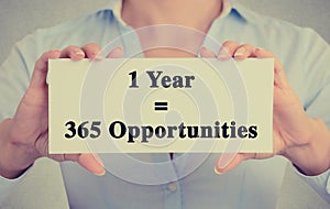 Closeup hands holding sign one year 365 opportunities message