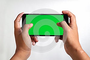 closeup of hands holding smart phones with green screen