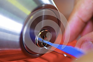 Closeup hands of locksmith using metal pick tools to open locked door