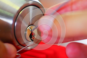 Closeup hands of locksmith using metal pick tools to open locked door