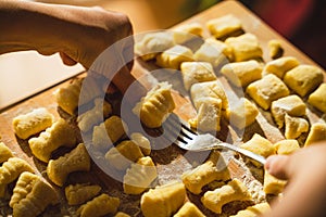 Closeup hands making traditional homemade italian gnocchi fresh pasta