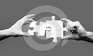 Closeup hands of man connecting jigsaw puzzle. Business solutions, success and strategy concept. Two hands trying to