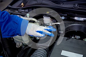 Closeup hands of man is mechanic repairing engine of car in the garage.