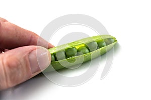 hands of man peeling fresh organic peas on white table background