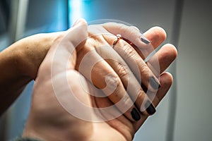 Closeup of hands man placing engagement ring in woman`s finger for love marriage