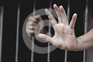Closeup on hands of man sitting in jail, prisoner concept, Hope