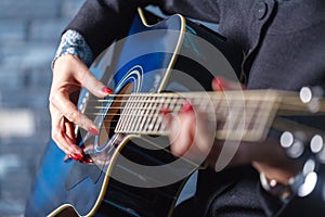 Closeup of hands of a musician playing acoustic guitar