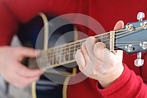 Closeup of hands of a musician playing acoustic guitar