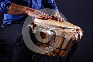 Closeup hands playing on djembe drum
