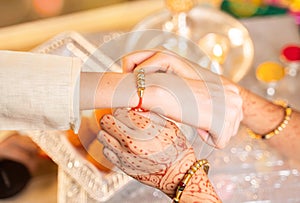 Closeup of hands, sister tying rakhi, Raksha bandhan to brother`s wrist during festival or ceremony - Rakshabandhan