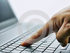 Closeup hands typing on laptop keyboard