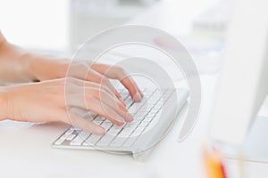 Closeup of hands using computer keyboard in office