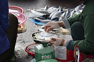 Closeup of hands weighting fresh fish on market