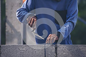 Closeup hands of the workers were plastering cement concrete on the walls with trowel at house construction site