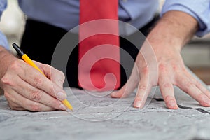 Closeup hands young caucasian architect man working drawing blueprint for planning building house.