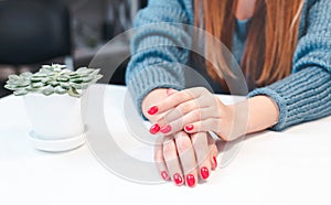 Closeup of hands of a young woman with red manicure