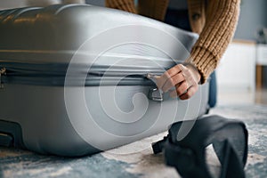 Closeup of hands zipping travel suitcase luggage