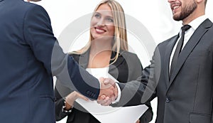 Closeup of handshake of business partners on the background of business team