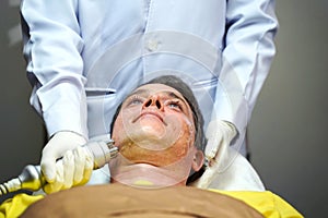 Closeup handsome man having therapy to stimulate facial skin and facial ultrasonic skincare treatment