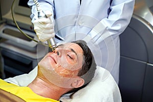 Closeup handsome man having therapy to stimulate facial skin and facial ultrasonic skincare treatment