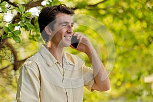 Closeup of handsome young man talking on phone at park