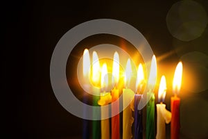 Closeup of Hanukkah menorah, or hanukkiah for Jewish holiday Hanukkah. Nine colored candles. Selective focus.