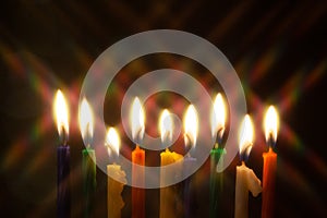 Closeup of Hanukkah menorah, or hanukkiah for Jewish holiday Hanukkah. Nine colored candles with star filter.