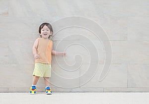 Closeup happy asian kid with smile face on marble stone wall textured background with copy space