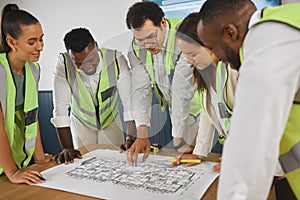 Closeup of a happy diverse multiracial group of architect colleagues analyzing a blueprint design on a building and