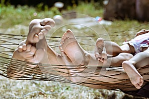Closeup of happy family lying on hammock barefoot
